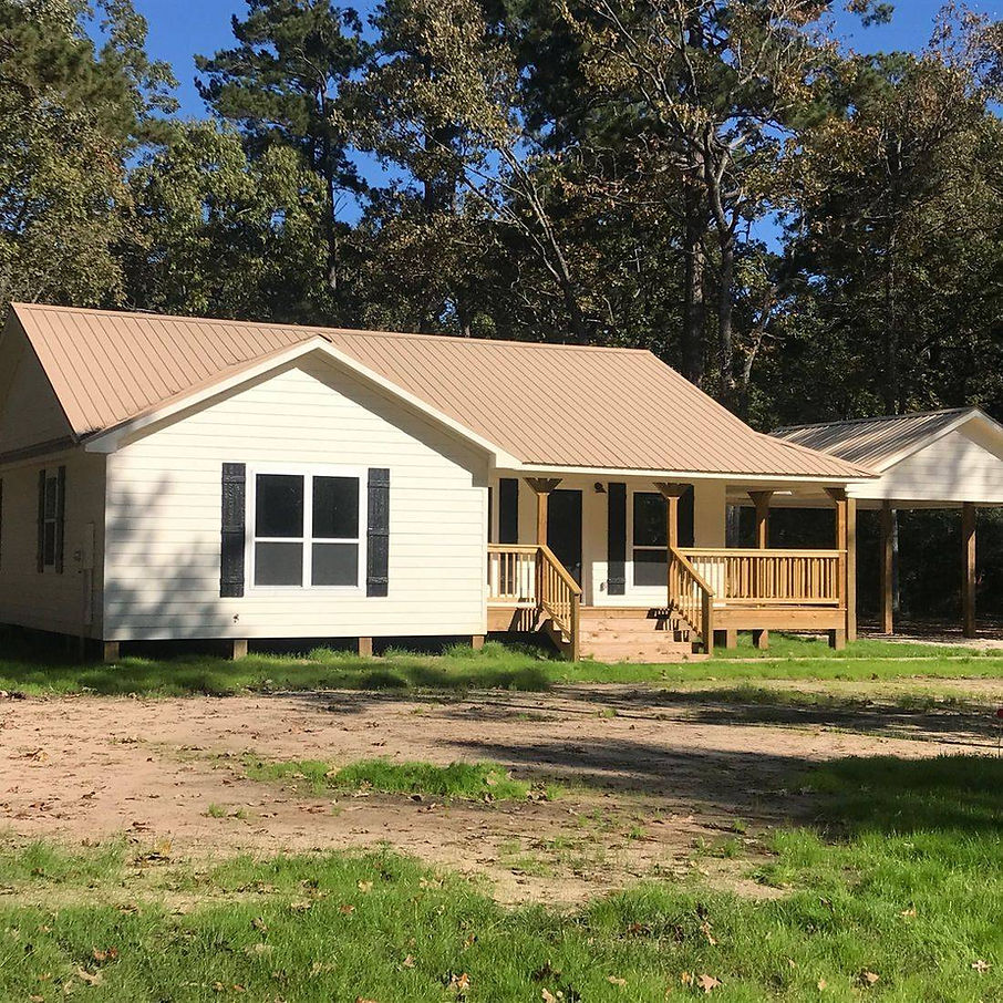 Custom shell home exterior built on a Texas property with completed siding, roofing, windows, and doors.